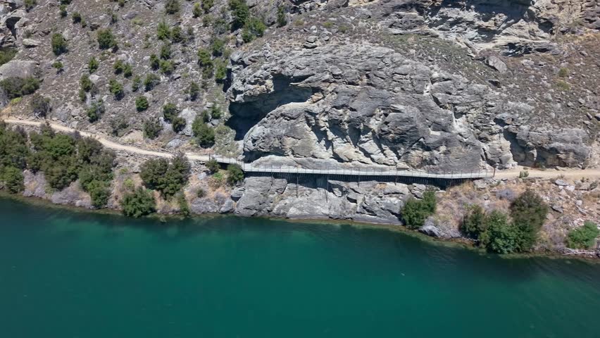 Cycling track along serene Lake Dunstan with historic sights, nature tranquil