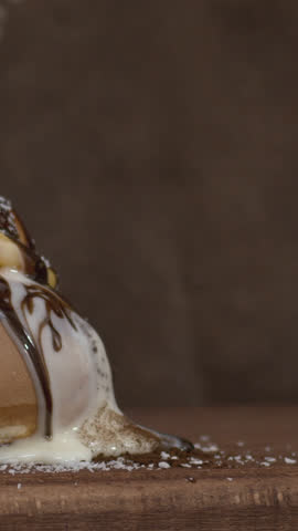 Dark chocolate fluid cascades over a French cake, revealing a rich chocolate filling, highlighting glossy textures, decadent layers, and cinematic dessert appeal for gourmet visual content.