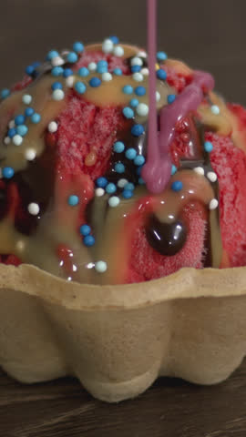 Rich chocolate sauce pours slowly over creamy chocolate ice cream in a crispy waffle cone, capturing decadence, texture, and indulgent dessert visuals—perfect for food promos and culinary videos.