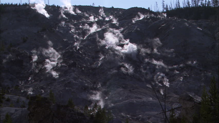 Still shot of mountain or hillside with steaming, smoldering earth