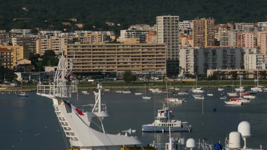 Scenic coastline of Corsica island seen from cruise ship with green hills rocky cliffs turquoise sea and coastal towns in sunlight Mediterranean travel destination natural landscape and summer view