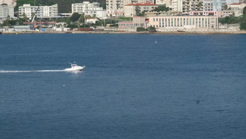 Scenic coastline of Corsica island seen from cruise ship with green hills rocky cliffs turquoise sea and coastal towns in sunlight Mediterranean travel destination natural landscape and summer view