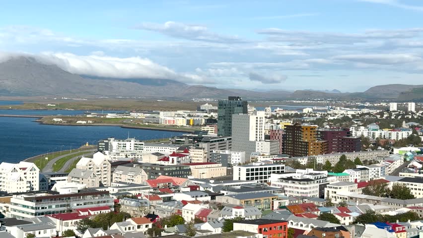 Discover the beautiful views of Reykjavik, showcasing a mix of modern buildings and charming homes along the waterfront. Experience the unique blend of nature and urban life.