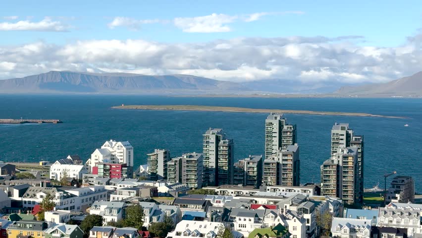 Discover the beautiful views of Reykjavik, showcasing a mix of modern buildings and charming homes along the waterfront. Experience the unique blend of nature and urban life.