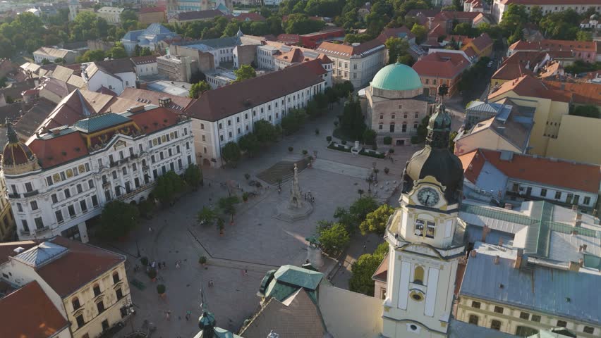 Aerial pullback showing Pécs’s central square, capturing the historic architecture and lively urban scene