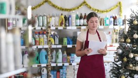 Women buy nail polishes and a set of makeup cosmetics against the background of a Christmas tree in the supermarket. Customers choose a set of cosmetics for festive New Year promotions and discounts - Powered by Shutterstock - Get 15% off with code: PIKWIZARD15