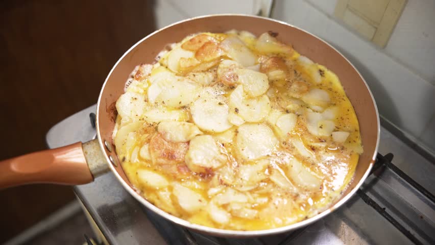 Top view of a pan cooking a traditional homemade Spanish omelette 
