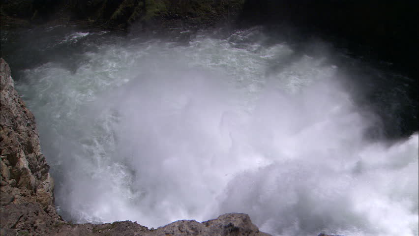 Zoom out from bottom to top of waterfall, view from top