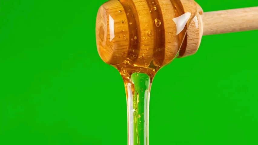 Golden honey dripping from a wooden dipper against a vibrant green background showcasing its natural sweetness - Powered by Shutterstock - Get 15% off with code: PIKWIZARD15