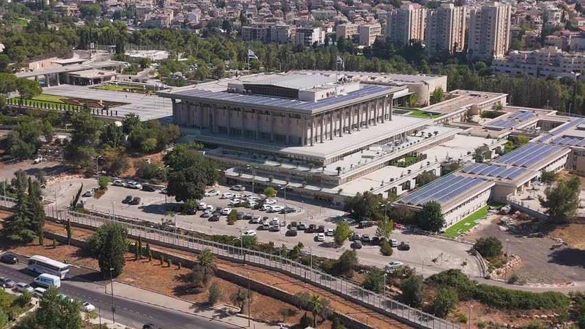 Aerial view of The Knesset building and parking lot surrounded by lush greenery and urban landscape, reflecting the vibrant life, Jerusalem, Israel.