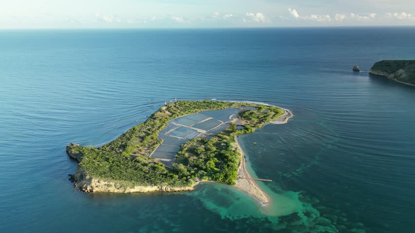Panoramic aerial of Cabra Island and surrounding ocean — crystal clear waters and tropical light. Perfect for stock travel collections