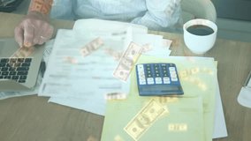 Senior man placing hand on laptop trackpad as woman reviewing finances with floating dollar bills. Finance, collaboration, senior, lifestyle, home office, productivity, retirement - Powered by Shutterstock - Get 15% off with code: PIKWIZARD15