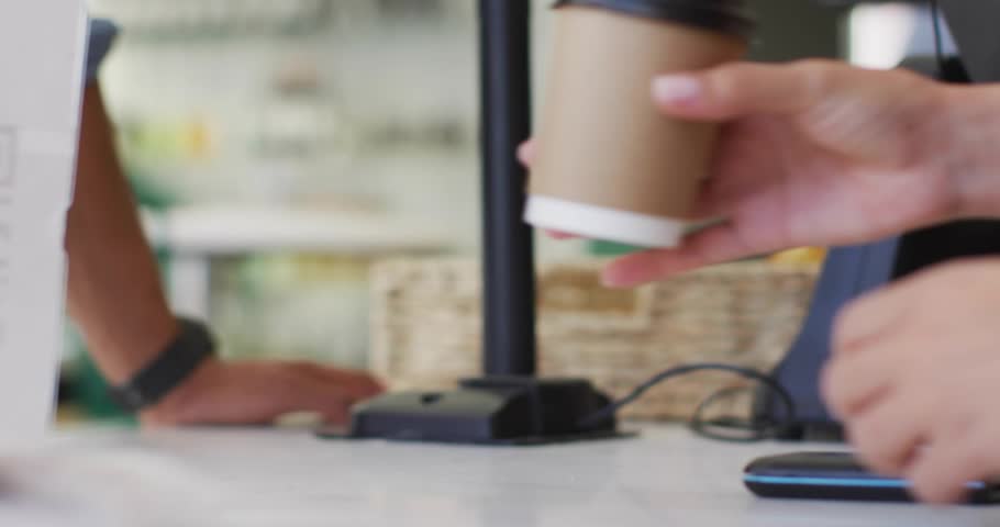 Barista placing cup by QR stand, icons appearing, customer tapping phone boosting likes lifting cup. Cafe, technology, social media, engagement, casual, contemporary, digital