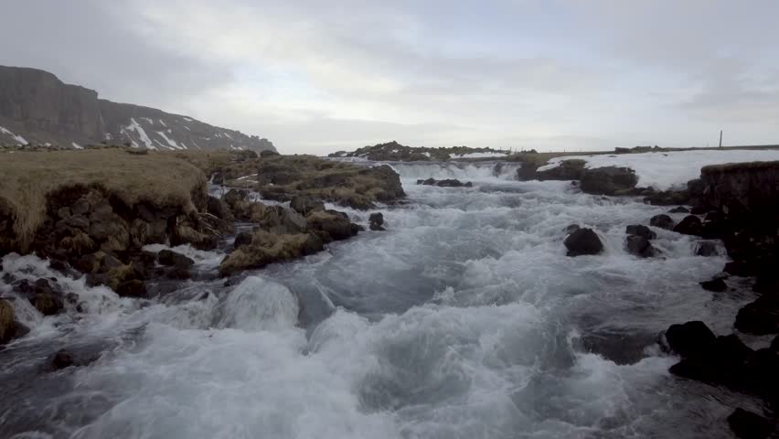 Winter landscape in Iceland with river and waterfall through the countryside in a typical Icelandic view. Travel and wild nature concepts