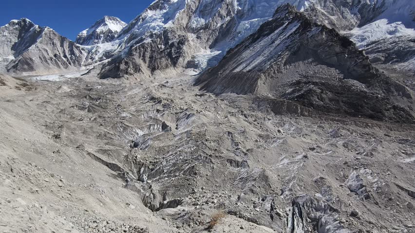 A vast landscape of the Himalayan mountain range near the Everest Base Camp under the blue afternoon sky