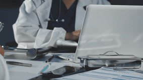 Medical professionals in scrubs discussing patient care, analyzing data on a clipboard in a meeting, Diagnosis and treatment planning. - Powered by Shutterstock - Get 15% off with code: PIKWIZARD15