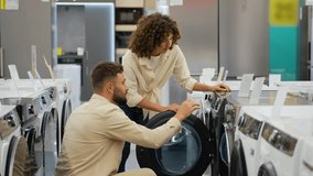 Couple choosing discounted washing machine in electronics store - Powered by Shutterstock - Get 15% off with code: PIKWIZARD15