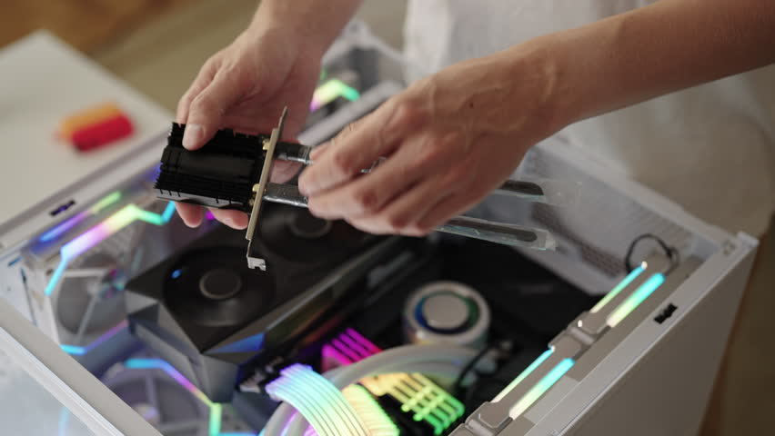 Closeup of technician male installing WIFI network card in new white computer build, adding wireless connectivity and upgrading gaming pc hardware components and technology. Shooting in slow motion.