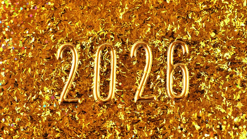 2026 gold numerals on a gold background.New Year and Christmas symbol golden wallpaper. Gold glitter scatters around the number two thousand twenty six. 4k footage