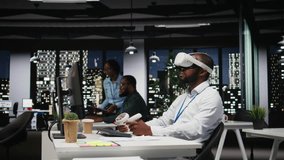 Young black businessman using virtual reality headset and other devices to build a strategy, forecasting projections and documenting risk assessment for success. Business goals. Camera A. - Powered by Shutterstock - Get 15% off with code: PIKWIZARD15