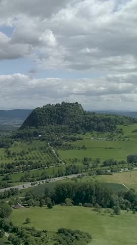Scenic view of a lush green landscape with a prominent hill under cloudy skies in southern France