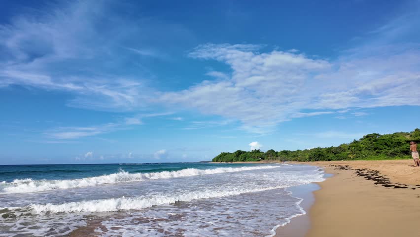 Aerial panorama of lush tropical coastline and ocean waves in Puerto Rico.