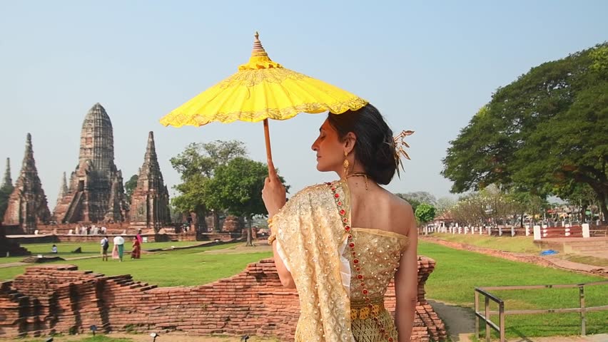 Thailand, Ayutthaya - march 15th, 2023: Woman in traditional Thai dress pose sightseeing visit ancient Buddha statue.Ayutthaya historical park. UNESCO World Heritage Site