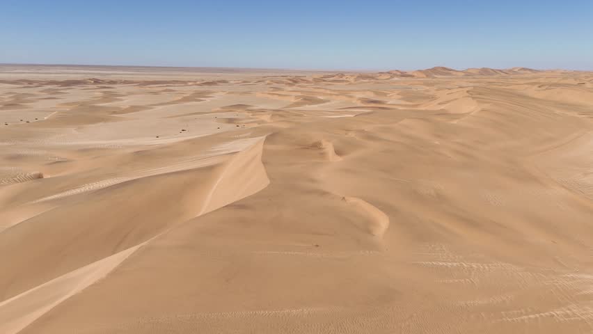 Drone view over the vast Namib Desert dunes, with soft shadows by the coastal winds of Swakopmund, Namibia.