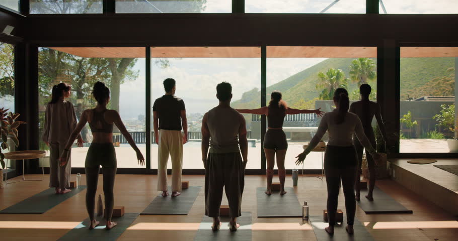 Back, people and stretching for yoga in class, holistic fitness and spiritual balance with instructor. Group, community and namaste pose for meditation, mindfulness and instructions of wellness hobby