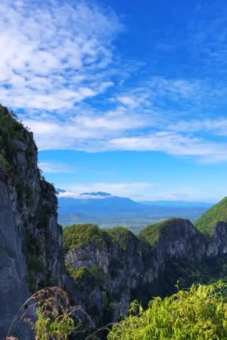 Majestic cliffs tower over lush valley below.