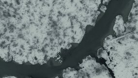 Aerial topdown shot of frozen river meandering through a snowy winter landscape during snowfall. - Powered by Shutterstock - Get 15% off with code: PIKWIZARD15