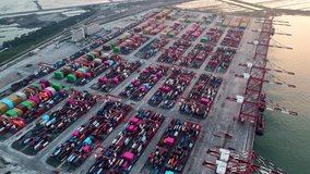 Drone View Container Terminal at Sunset with Stacked Containers and Cranes. Modern Logistics Global Shipping and Freight Transportation Hub for International Trade and Cargo in Large Colorful Asia 4k - Powered by Shutterstock - Get 15% off with code: PIKWIZARD15