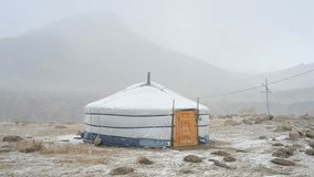 A lone Mongolian ger stands against a foggy mountain as an autumn snowstorm intensifies. A scene of nomadic resilience and survival against the harsh, encroaching winter weather. - Powered by Shutterstock - Get 15% off with code: PIKWIZARD15