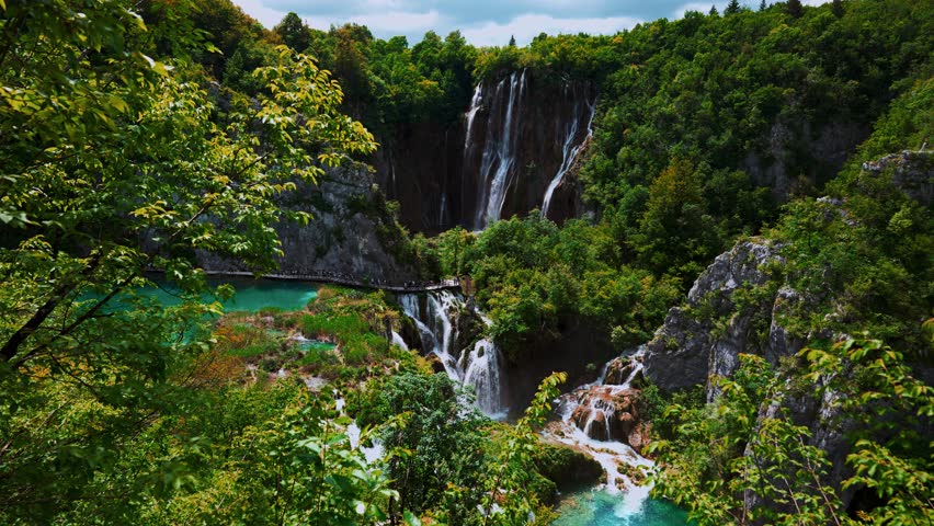 Waterfalls surrounded by green vegetation and cliffs in Plitvice Lakes National Park, Croatia