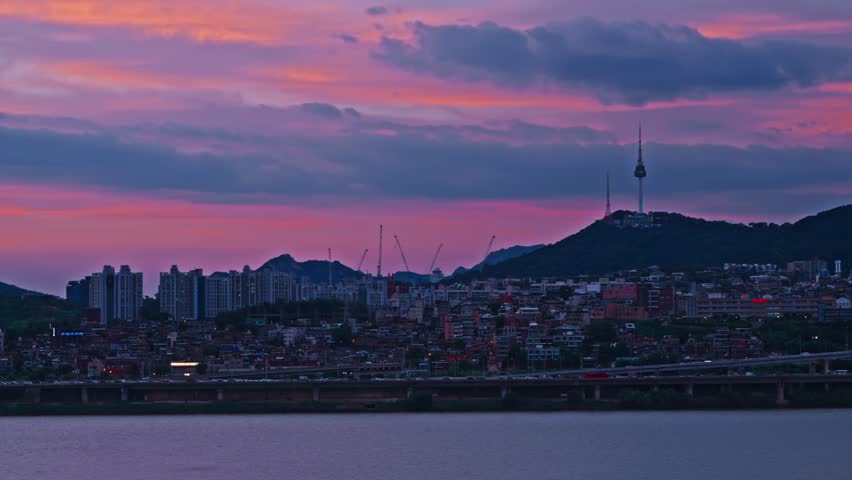 Incredible purple and pink sunset clouds over the Yongsan district skyline and the iconic N Seoul Tower on a summer evening in South Korea