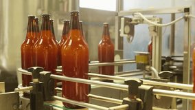 See amber beer bottles move along a dynamic conveyor belt, part of an automated bottling process. Perfect for showing beverage production and industry solutions. - Powered by Shutterstock - Get 15% off with code: PIKWIZARD15