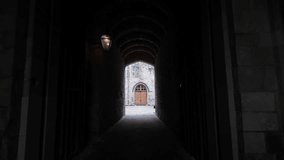 Dark castle archway creating a path to an ancient building and bright courtyard.POV - Powered by Shutterstock - Get 15% off with code: PIKWIZARD15