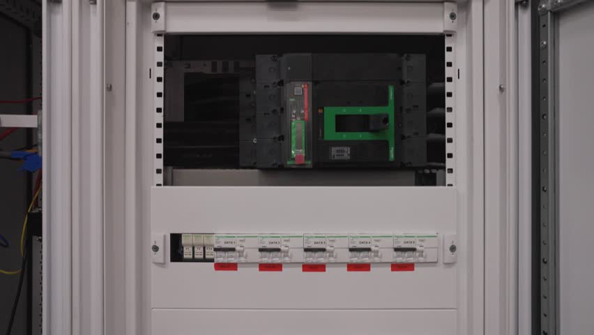 A clean shot of a modern electrical distribution board, showing the neat rows of circuit breakers and the large main breaker that controls the power supply for a facility.