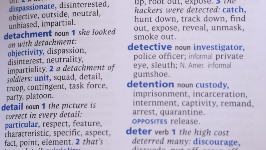Looking at detective word in dictionary through a magnifying glass