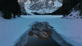 Breathtaking winter view of the frozen and snow-covered Lago di Braies (Pragser Wildsee) in the Dolomites, Italy. A majestic mountain peak, lit by sunrise, is reflected in the water. - Powered by Shutterstock - Get 15% off with code: PIKWIZARD15