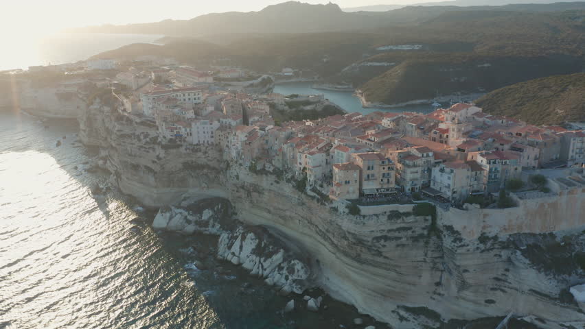 Bonifacio, Corsica Aerial drone circling shot cliffs of at sunset golden light rugged coastline limestone the turquoise Mediterranean Sea iconic French island landscape