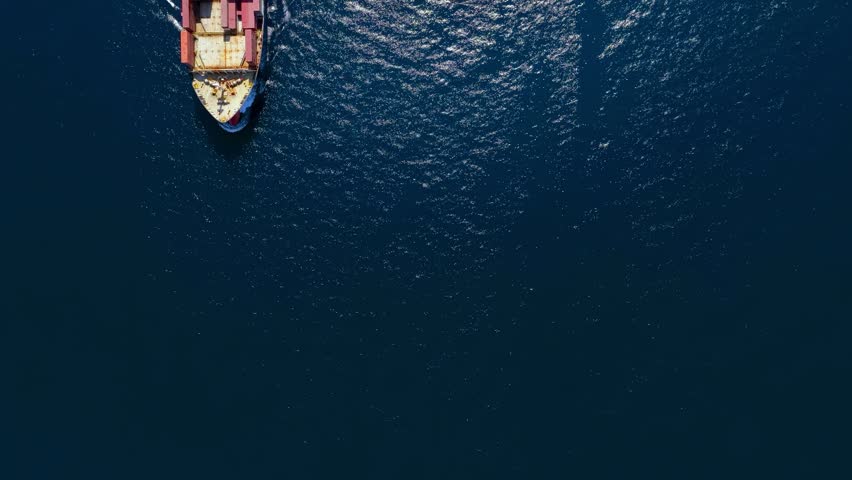Aerial overhead view of a cargo container ship travling over the ocean as a concept for industry and shipping with copy space