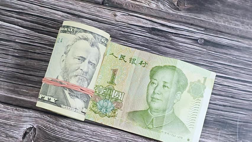 Chinese Yuan money bill and 50 USD fifty American dollars banknotes cash money rolled up with a rubber band, features Ulysses S. Grant, American and Chinese money, money exchange rate