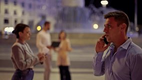 A confident businessman and a smart businesswoman finalize an agreement with a firm handshake, exchanging important documents under the vibrant city lights. - Powered by Shutterstock - Get 15% off with code: PIKWIZARD15