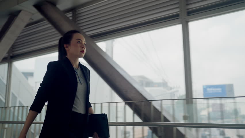 Asian businesswoman in formal suit using smartwatch while holding tablet. Concept of productivity, multitasking, digital work lifestyle, and time management. - Powered by Shutterstock - Get 15% off with code: PIKWIZARD15
