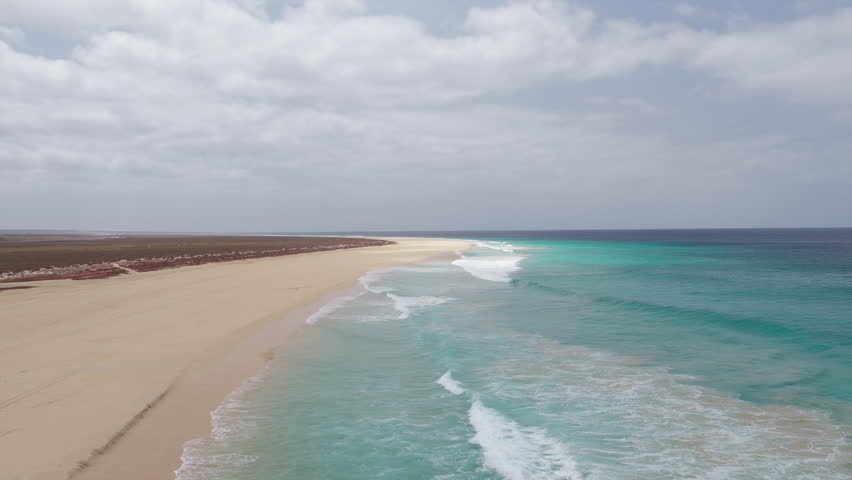 Drone footage of Santa Monica Beach,showcasing endless white sand, turquoise waves, and a pristine,summer concept,Boa Vista, Cape Verde.