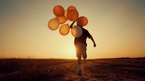 Feel happiness and joy, little child having fun in nature, running with balloons . Slow motion back view with carefree boy enjoying simple life in countryside, human and nature, positive emotion - Powered by Shutterstock - Get 15% off with code: PIKWIZARD15