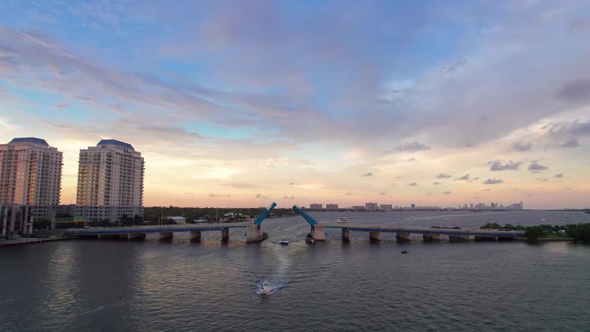 Aerial view of Biscayne Bay with JFK Causeway drawbridge connecting islands under a sky tinged with sunset hues, Miami, Florida, United States.