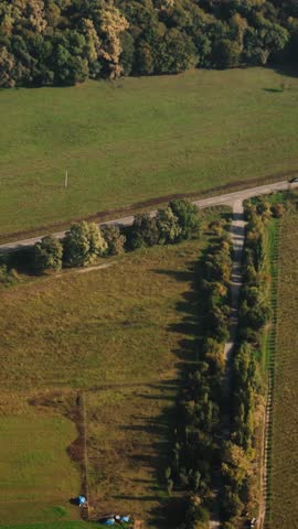 A small plane flying over colorful autumn landscapes at sunset