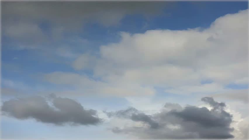 A dynamic sky scene featuring a mix of light and dark clouds against a clear blue sky, showcasing atmospheric changes.